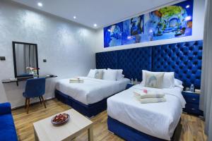 舍夫沙万Hotel Dar Annasr的酒店客房设有两张床和一张桌子。