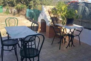 La AulagaCasa Rural Paraiso de Emilia的庭院设有两把桌子和椅子,还有盆栽植物