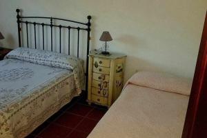La AulagaCasa Rural Paraiso de Emilia的一间卧室配有一张床和一个带灯的梳妆台