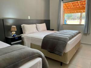 圣代佩德罗Santana's Ranch的一间卧室设有两张床和窗户。
