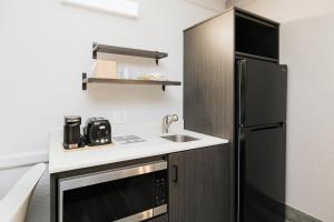 贝敦Studio 6 Baytown, Tx - Garth Road的一间带水槽和冰箱的小厨房