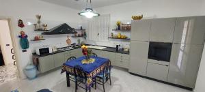 马尔萨拉La Villetta di Sabrina的厨房配有桌子、炉灶和冰箱。