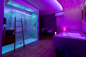 拉西约塔Studio romantique jacuzzi ou spa balneo privatif et jardin Au temps des cerises La Ciotat的带淋浴和盥洗盆的紫色浴室