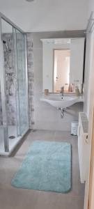 丰斯多夫TOP 06的浴室设有水槽、镜子和蓝色地毯。