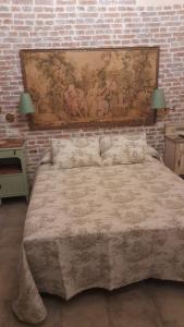 坎加斯-德奥尼斯La Posada del Canario的一间卧室设有一张带砖墙的大床