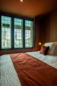 布鲁日Guest House La Civière d'or的一间卧室设有一张大床和窗户。