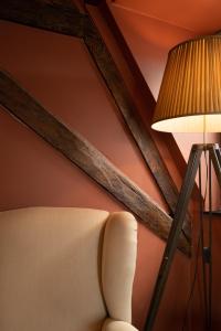 布鲁日Guest House La Civière d'or的房间里的一盏灯和一把椅子