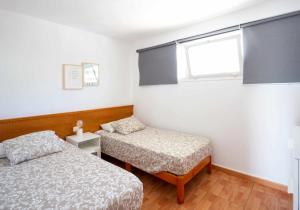 梅罗那瑞斯Apartamento Maypa 4 Arena的一间卧室设有两张床和窗户。