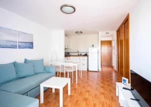 梅罗那瑞斯Apartamento Maypa 4 Arena的一间带蓝色沙发的客厅和一间厨房