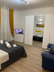 亚历山德里亚Savonarola Almarc 2的一间卧室配有一张床、一台电视和一张沙发