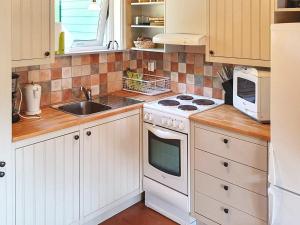龙讷比Holiday home in Ronneby的一间带白色炉灶的厨房 水槽旁的顶部烤箱
