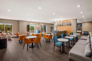 萨尔弗La Quinta Inn & Suites by Wyndham Sulphur Lake Charles的餐厅设有桌椅和沙发。