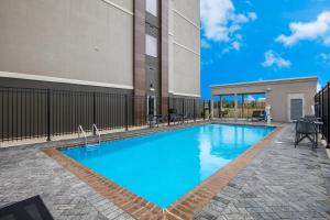 萨尔弗La Quinta Inn & Suites by Wyndham Sulphur Lake Charles的大楼前的蓝色海水游泳池