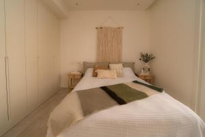 蒂瓦特Lustica Bay Apartment Ana Marija By 2bhome的卧室配有一张带两张桌子的大型白色床