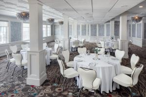 汉普顿海边阿什沃斯酒店的宴会厅配有白色的桌子和白色的椅子