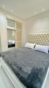 丹吉尔Big appartment near soccer stadium in Tangier的一间卧室设有一张大床和一个大镜子