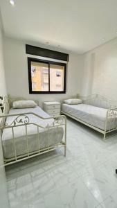 丹吉尔Big appartment near soccer stadium in Tangier的一间卧室设有两张床和窗户。