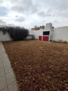 卢汉德库约Casa Familiar para hasta 6 personas , Lujan de Cuyo , Mendoza的一个大院子,有白色的建筑,有红色的门