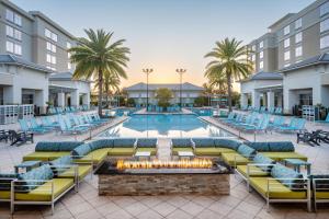奥兰多SpringHill Suites by Marriott Orlando at FLAMINGO CROSSINGS Town Center-Western Entrance的一个带躺椅和火坑的室外游泳池