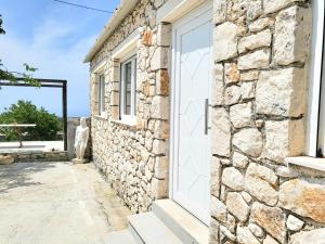Ágios NikólaosAngelos Stone Cottage的白色门和窗户的石头建筑