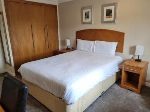 达宁顿堡Kegworth Hotel & Conference Centre的一间卧室配有一张带2个床头柜的大型白色床
