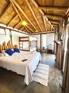 维加伊托Casa Lodge (primera fila)的一间带一张大床的卧室,位于一个拥有木制天花板的房间