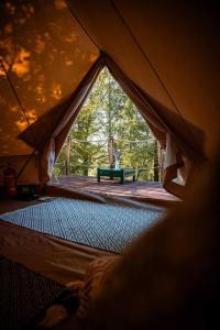 DrábskoYatu Ecological Glamping的帐篷的后面设有绿色长椅