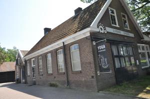 Noord-SleenBed & Breakfast de Hoefstal的一座旧砖砌的建筑,上面有标志