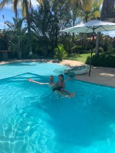 普拉亚科罗纳多Casa Swell Coronado的两个人坐在游泳池里