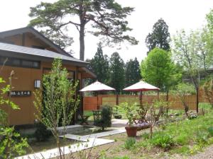 妙高Kofukan - Vacation STAY 67964v的一个带遮阳伞和房子的花园