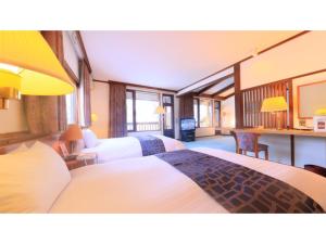 青森Sukayu Onsen Hakkoda Hotel - Vacation STAY 66845v的酒店客房配有两张床和一张书桌