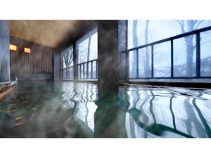 青森Sukayu Onsen Hakkoda Hotel - Vacation STAY 66845v的一间设有窗户的池水客房