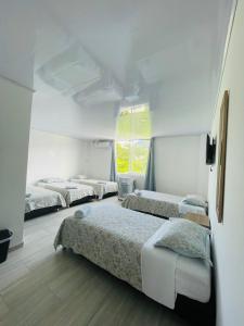 圣安德烈斯BLUE ISLAND HOTEL的带四张床和窗户的客房