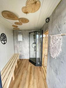 里沃RResort - nowe KLIMATYZOWANE domki z PODGRZEWANYM Basenem, Sauna, WiFi, parking w cenie!的带淋浴和长凳的房间