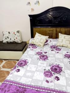 شقة مفروشة 5 سراير في كامب شيزار的床上有紫色和白色的被子