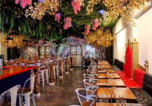 巴拿马城Hotel Mio Panamá的餐厅设有桌椅和鲜花天花板