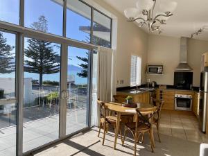 凯库拉Kaikoura Waterfront Apartments的一个带桌椅和大窗户的厨房