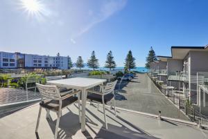 凯库拉Kaikoura Waterfront Apartments的公寓的阳台配有桌椅