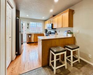 博伊西The Getaway SE Boise Condo Across the street from Greenbelt, Bown Crossing and Boise River 3BD 3Bath, 4 beds! Lovely, Homey, Dining table seats 6的厨房配有柜台和2张凳子