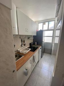 里斯本Beato Typical House的厨房配有白色橱柜和水槽