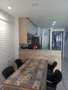 福塔莱萨LIV INN Apartamento na Beira-Mar Fortaleza的厨房配有木桌、椅子和柜台