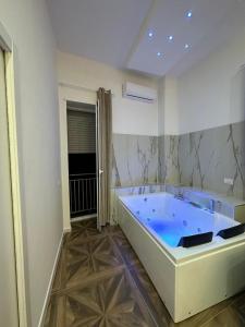 那不勒斯San Ferdinando suite room的白色客房内的大蓝色浴缸