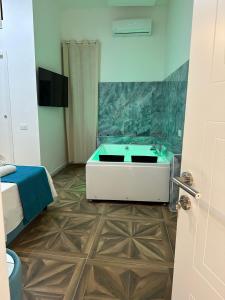 那不勒斯San Ferdinando suite room的一间带浴缸的浴室和一台电视机
