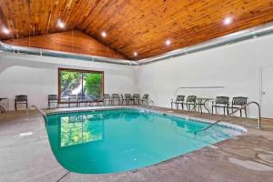 赛维尔维尔2-Bedroom Cabin with 2 Master Suites, Loft, Half-Bath and hot tub in a Serene Resort Setting的一个带椅子和木制天花板的大型游泳池