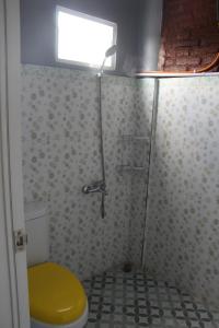 普兰巴南Georium Dunia的浴室设有黄色卫生间和窗户。