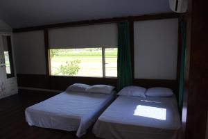 普兰巴南Georium Dunia的两张床位于带窗户的房间内