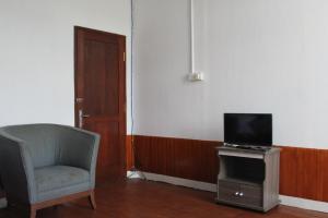 普兰巴南Georium Dunia的客厅配有椅子和电视