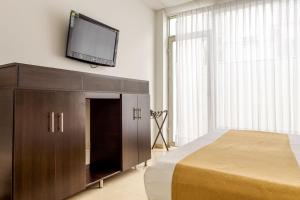 梅尔加Hotel Manantial Melgar Torre 2的卧室配有一张床和壁挂式平面电视。