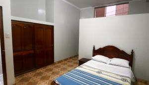 哈恩Hostal Las Palmeras的一间卧室配有一张带木制床头板的床和窗户。