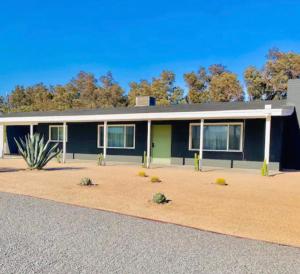 沙漠温泉Modern + Midcentury House in B Bar H Ranch的一座绿树成荫的蓝色房子